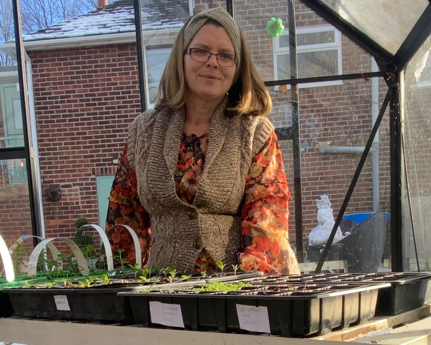 Nic from Collie Flowers in greenhouse with trays of seedlings